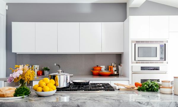 A bright white kitchen with a stone benchtop