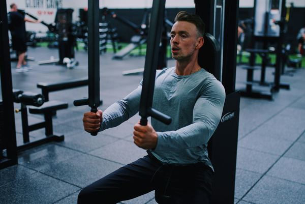 A man doing strength rehab on a gym machine